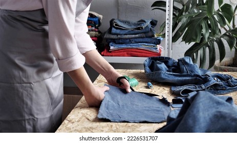 Denim Jeans Recycle and Reuse. Sustainable Fashion. Designer sew from used denim fabric, old jeans. Upcycling process brings new life to old jeans - Shutterstock ID 2226531707