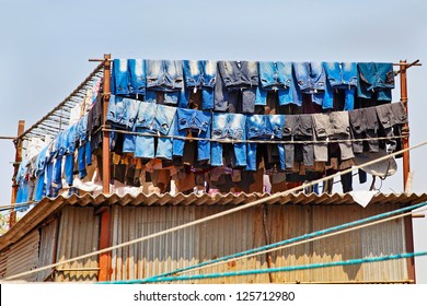 Denim Jeans Washed And Hanging Out To Dry In The Hot Indian Mid Day Sun At A Commercial Washing Factory, Dhobhi Ghat. Location Of Shot Bombay India