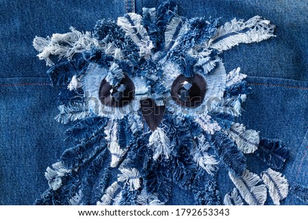  Denim owl - blue denim jeans patchwork pattern. Concept of old jeans reuse and natural resources preserving