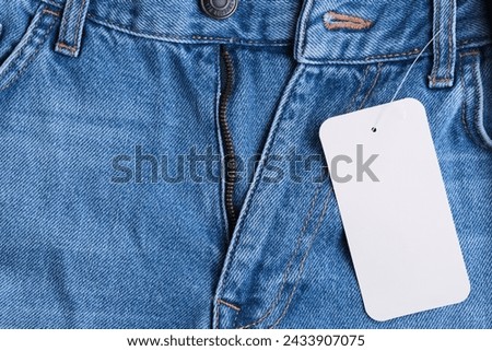 Denim pants with an unbuttoned fly and label hanging on them Foto d'archivio © 
