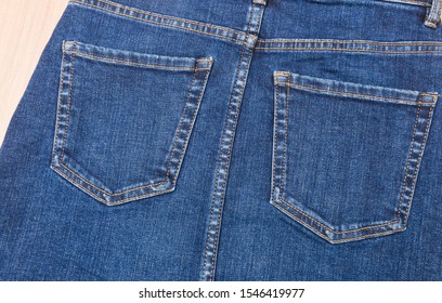 Denim Texture. Back Pocket Of The Blue Jeans On Wooden Background
