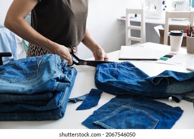 Denim Upcycling Ideas, Using Old Jeans, Repurposing Jeans, Reusing Old Jeans, Upcycle Stuff. Woman seamstress cut and repair old blue jeans in sewing studio.
