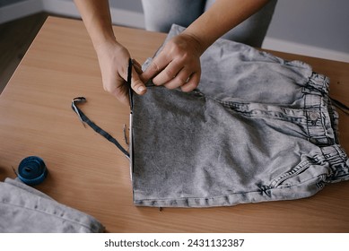 Denim Upcycling Ideas. woman indoors making old clothes new and trendy - Powered by Shutterstock