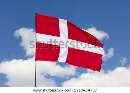 Denmark flag isolated on the blue sky with clipping path. close up waving flag of Denmark. flag symbols of Denmark.