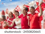 Denmark football supporter on stadium. Danish fans on soccer pitch watching team play. Group of supporters with flag and national jersey cheering for Denmark. Championship game.