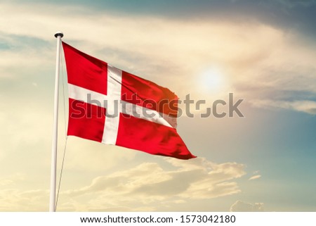 Denmark national flag cloth fabric waving on the sky with beautiful sun light - Image