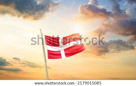 Denmark national flag waving in beautiful clouds.