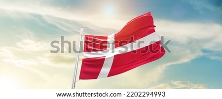 Denmark national flag waving in beautiful sky.