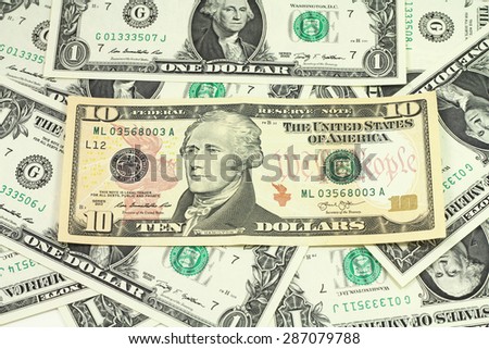 The denomination of ten dollars on a background of dollar bills