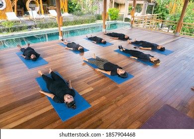 Denpasar, Bali / Indonesia - 15 May 2020: A Group Of People Does Yoga And Laying Down Relax Meditation Wearing Black Clothes And The Place Made Of Bamboo.