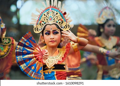 Denpasar, Bali island, Indonesia - June 11, 2016: Portrait of beautiful young Balinese woman in ethnic dancer costume, dancing traditional temple dance at art and culture festival parade.