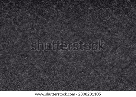 Dense chromo board material surface captured with professional 5x microscope lens showing detailed rough paper texture and pressed cellulose structures. Full frame macro shot under high magnification captures dark grey uncoasted cardboard and messy organic fibers on seamless packaging backdrop. Universal textured background for web design layouts, industrial paper manufacturing presentation, mobile app interface design, minimalist poster graphics and modern commercial art banner. Concept of recycled material durability, rustic industrial design and versatile abstract packaging assets with copy space for text