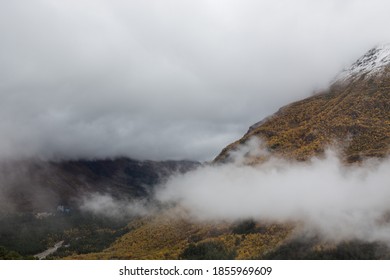 Dense clouds enveloped the mountain, covered with autumnal golden trees and snow.