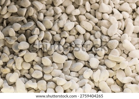 A dense collection of smooth, rounded white pebbles and stones. A serene and zen-like texture ideal for garden landscaping, spa-themed backgrounds, or minimalist interior design.