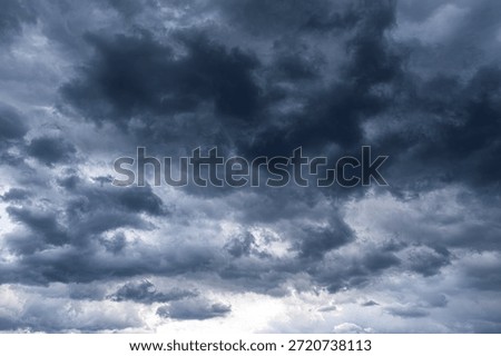 Dense dark storm clouds fill the overcast sky with a soft light glowing from below.