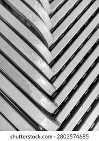 a dense diagonal pattern of stacked gray metal chairs with details