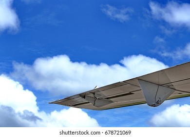 Dense Fluffy Puffs of White Clouds Blue sky at high level attitude, view from window airplane, copy space, wings of aerocraft