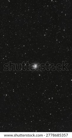 A dense globular star cluster containing thousands of glowing stars is positioned against the dark backdrop of outer space.
