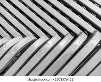 a dense horizontal pattern of stacked gray or silver metal chairs with great detail