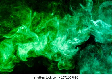 Dense Multicolored  Green Smoke  On A Black Isolated Background. Background Of Smoke Vape