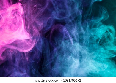 Dense Multicolored Smoke Of Pink,  Blue And Purple Colors On A Black Isolated Background. Background Of Smoke Vape
