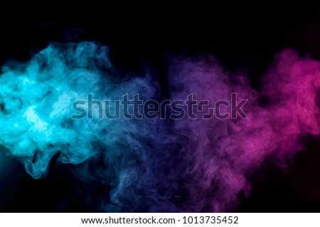 Dense multicolored smoke of   red, purple and pink colors on a black isolated background. Background of smoke vape