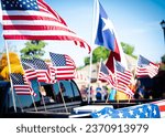 Dense of Texas and American flags on cargo bed of modern pickup truck driving on residential street smalltown Fourth of July parade, Dallas, Texas, USA blurry diverse people. Independence Day patriot