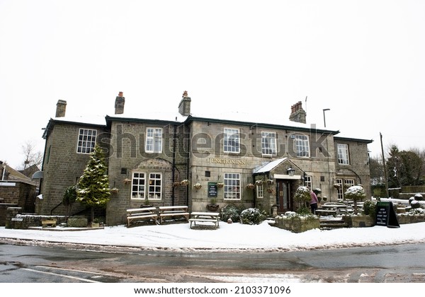 DENSHAW, UK -\
JANUARY 07, 2022: The Juntion Inn, a public house at the main\
crossroads in the centre of the village on cold snowy winter day,\
Saddleworth, Oldham, Greater\
Manchester