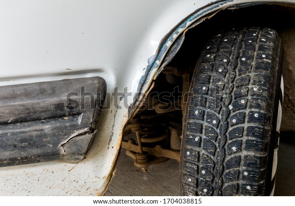 Dent on\
the body of a white car after a car\
accident.