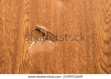 Dent on the plastic damage surface of the imitation of artificial wood disturbed background on the coating broken.