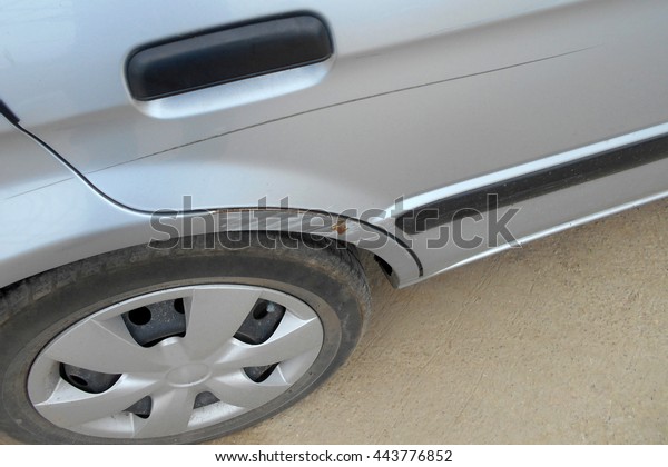 A dent on the right of a saloon car (damage\
from crashed accident)