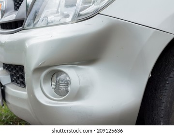 A dent in the right front  of a  car