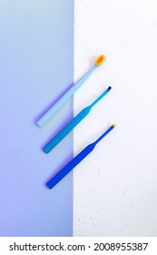 Dental Care Conept. Dentistry Tools. Three Blue Toothbrushes For Braces On White And Blue Background. Still Life, Flat Lay. Vertical Photo, Story Instagram With Copyspace.
