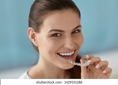 Dental Care. Smiling Woman With Healthy Teeth Using Removable Clear Braces Aligner, Orthodontic Silicone Trainer. Portrait Girl With White Smile Using Invisible Whitening Tray