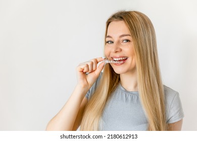 Dental care. Smiling woman with healthy teeth using removable clear braces aligner, orthodontic silicone trainer. - Shutterstock ID 2180612913