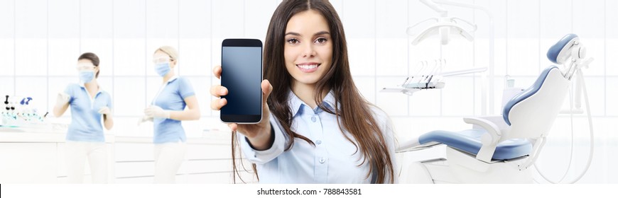 Dental Care Smiling Woman Showing Smart Phone On Dentist Clinic With Dentist's Chair Background Web Banner Template