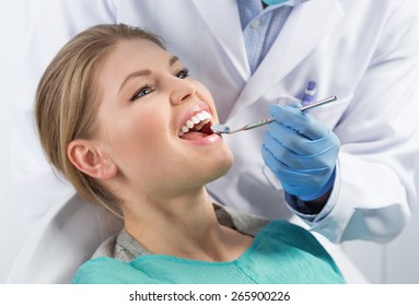 Dental Care And Treatment. Portrait Of Young Woman Sitting In Armchair Treating Her Teeth In Dentist Office. 