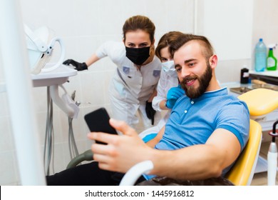 Dental Clinic. A Satisfied Patient Takes A Selfie Picture With The Doctors To Leave A Review On The Hospital Website.