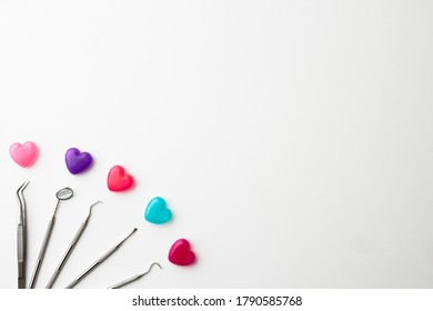 dental equipment and heart shaped capsules on white background