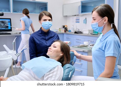 Dental examination, treatment of teeth, patient mature woman in chair and doctor dentist with an assistant. Medicine, dentistry and health care concept - Powered by Shutterstock