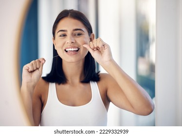 Dental floss, teeth and woman in mirror of bathroom for oral hygiene, morning routine or gum health. Beauty, wellness and self care with girl and big smile in reflection for cleaning tooth and mouth - Powered by Shutterstock