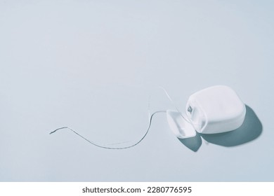Dental floss in a white box on a blue background.