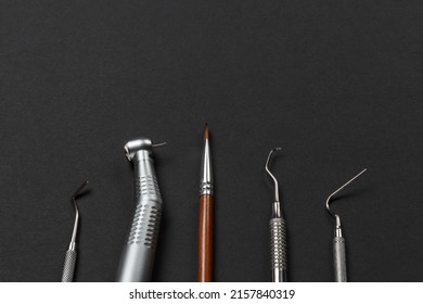 Dental handpiece with bur, a brush, a curette, a plugger, a dental restoration instrument on the black background. Medical tools. Top view.