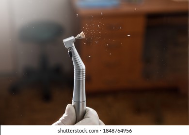 Dental highspeed handpiece and polishing brush in action with dark background