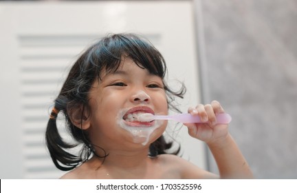 Dental Hygiene. Asian Cute  Child Girl Or Kid Brushing Her Teeth By Toothbrush In The Bathroom. Healthcare Concept. 