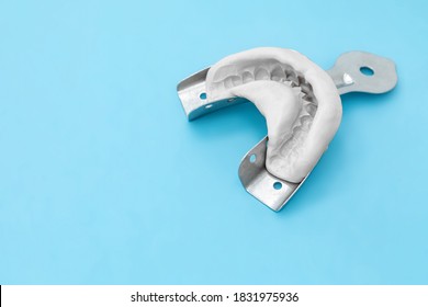 Dental Impression Of The Jaw Of Silicone Material On A Blue Background. The Imprint Of The Tooth Row Of High Precision.