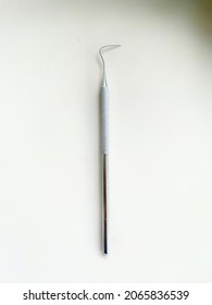 A dental instrument made of stainless steel, called dental sonde halfmoon on white table background