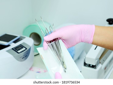 Dental Instrument Packaging In A Sterilization Bag. A Medical Worker Puts A Medical Instrument In A Device For Disinfection And Cleaning Of Germs. 