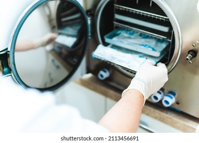 Dental instruments are sterilized in the sterilizing oven by the dentist's assistant - Shutterstock ID 2113456691