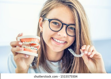 Dental invisible braces or silicone trainer in the hands of a young smiling girl. Orthodontic concept - Invisalign. - Shutterstock ID 1515575504